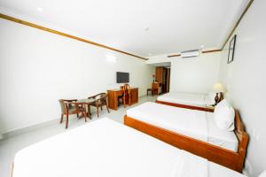 PursatPursat Riverside Hotel & Spa的酒店客房配有两张床和一张书桌