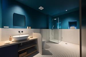 七尾ROOM design hotel的浴室设有蓝色的墙壁、水槽和淋浴。