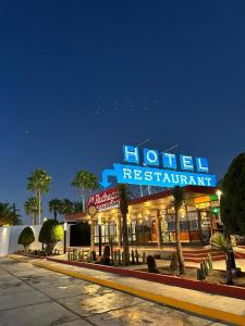 马特瓦拉Hotel El Pedregal的街道上带有 ⁇ 虹灯标志的酒店餐厅