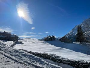 奇萨瓦玛兰科Baita Chalet La Masun beautiful view的雪覆盖的山坡,有石墙和山
