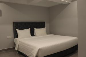 金边Parc21 Luxury Boutique Hotel的卧室配有一张带白色床单和枕头的大床。