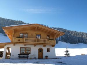 格英Chalet Der Tyroler Adler im Zentrum的雪地里带阳台的木屋