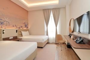 怡保Cititel Express Ipoh的酒店客房设有两张床和电视。