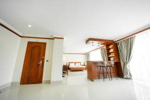 PursatPursat Riverside Hotel & Spa的客厅设有木门和桌子