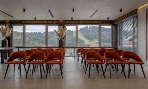布克维Didukh Eco Hotel&Spa的一间会议室,配有橙色椅子和桌子