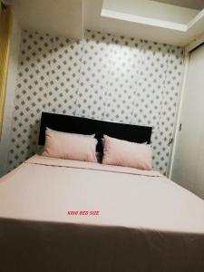 马尼拉Grand Riviera suite Condotel的一张带两个粉红色枕头的床