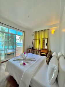 马富施Leisure Boutique Maafushi 维尼家的卧室设有白色床,享有海景