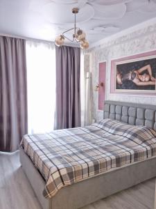 基希讷乌ApartHotel City Centrum的一间卧室配有一张大床和一张铺着条纹毯子