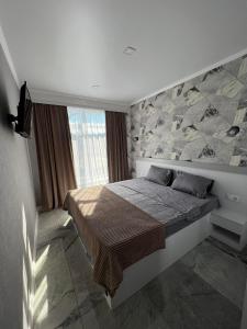 基希讷乌ApartHotel City Centrum的一间卧室设有一张带石墙的大床