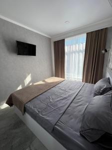 基希讷乌ApartHotel City Centrum的一间卧室设有一张大床和一个窗户。