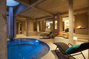 巴特特尔茨Hotel BERGEBLICK的一个带椅子的房间和一个客厅的大型游泳池