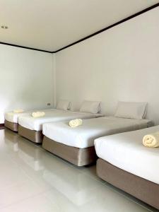 王南安科Ozone Chomdao Resort的白色墙壁的客房内的三张床
