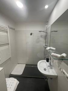 博登斯多夫George-Beach Apartment Ossiachersee/Gerlitzen的白色的浴室设有水槽和淋浴。