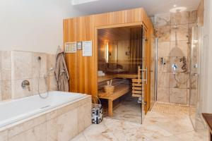 莱门托斯卡纳别墅酒店的大型浴室设有浴缸和淋浴。
