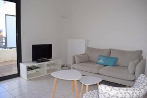 佩罗斯-吉雷克Bel appartement entièrement rénové 5 personnes au centre ville de PERROS-GUIREC - Ref 923的客厅配有沙发、电视和桌子