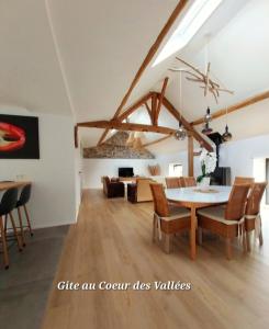 库万Au Cœur des Vallées的用餐室以及带桌椅的起居室。