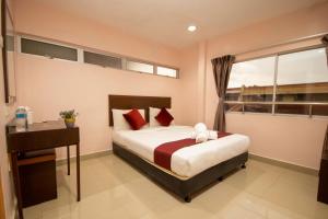 Batang BerjuntaiSun Inns Hotel Bestari Jaya的一间卧室配有一张床、一张书桌和一个窗户。