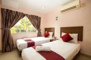 Batang BerjuntaiSun Inns Hotel Bestari Jaya的酒店客房设有两张床和窗户。