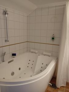 塔尔伯格托尔堡斯农场酒店的白色瓷砖浴室内的白色浴缸