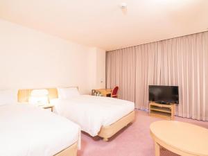 汤泽町苗场王子大饭店的酒店客房设有两张床和一台平面电视。