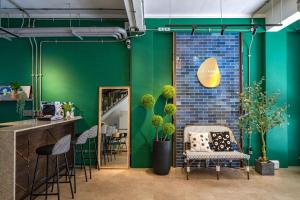 花莲市蓝屋市区民宿的一间设有绿色墙壁、椅子和柜台的房间