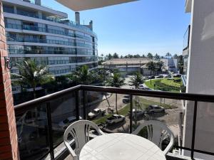 圣劳伦斯海滨Apartamento pé na areia em Riviera de São Lourenço的一个带桌椅的阳台和一座建筑