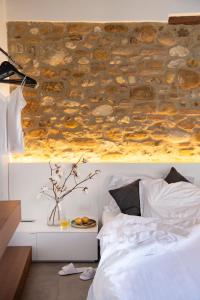 瓦尔的圣卡西亚诺萨尔瓦多妮卡酒店的卧室配有石墙,位于床上方