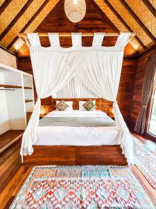 乌鲁瓦图Kayu Mama Resort and Spa的一间卧室配有一张带蚊帐的床