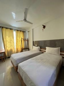 马富施Leisure Boutique Maafushi 维尼家的一间卧室设有两张床和窗户。