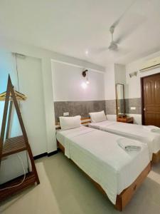 马富施Leisure Boutique Maafushi 维尼家的酒店客房设有两张床和窗户。