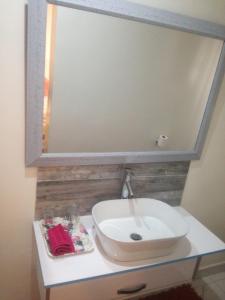 索韦托MajaK Guesthouse的浴室设有水槽和镜子,位于柜台上