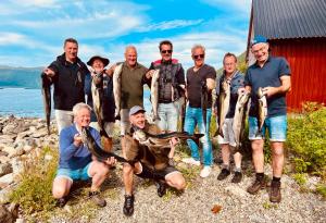 RekdalAwesome Fishing, Boating and Nature Experience at Fiskesenter Birkeland的一群人把捕获的鱼抱起来