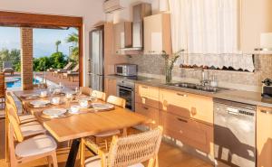 ÉvyirosIris Villas Lefkada - Karavi Villa的一间带木桌的厨房和一间餐厅