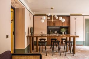 普罗旺斯艾克斯法兰西精神皮贡奈特酒店的厨房配有一张大木桌和凳子