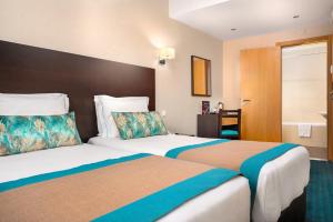 里斯本DAH酒店 - 多姆阿丰索亨利克斯的一间酒店客房,房间内设有两张床