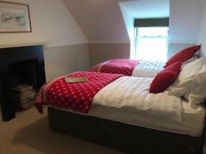 The Bothy, Gallin, Glenlyon, Perthshire的一间卧室配有两张带红白毯子的床