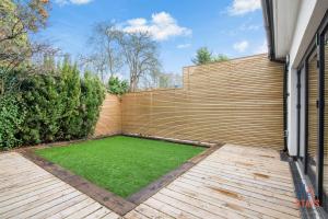 奥平顿OnSiteStays New Large modern 4 bed, Parking, Wifi, 2 x Bathroom的后院设有木栅栏和绿色草坪