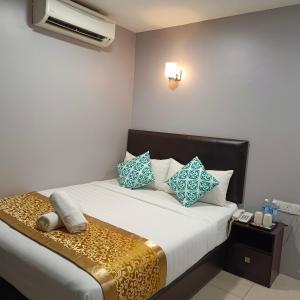 雪邦Royale City Hotel - 10 min from KLIA KLIA 2 Airport的一间卧室配有一张带蓝色和白色枕头的床