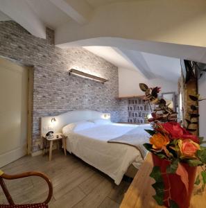 米兰查理酒店的一间卧室设有一张床和砖墙