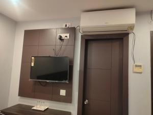 巴特那HOTEL IMF的一间墙上配有电视的房间和一扇门