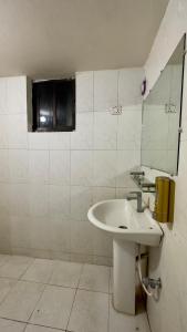 达卡Appayan Guest House Baridhara (Bhagyakula Building)的白色的浴室设有水槽和镜子