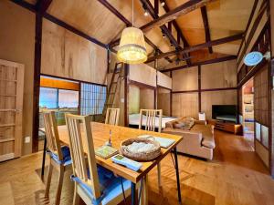 熊本SUMITSUGU HOUSE West的一间带桌子和沙发的用餐室