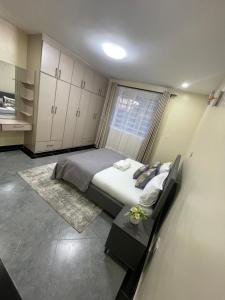 纳库鲁Naka Tranquil Suite with Ample Secure Parking的一间卧室设有一张大床和一个窗户。