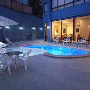 圣地亚哥阿尔卡拉德尔里奥酒店的一个带桌椅的游泳池和一个庭院