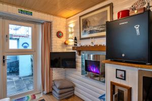 廷塔杰尔Finest Retreats - Treknow Summerhut的客厅配有平面电视和壁炉。