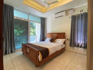 瓦尔卡拉Grand Residency & Resort的一间卧室设有一张床和一个大窗户