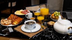 南希Hotel De Guise Nancy Vieille Ville的一张桌子,上面有早餐食品和饮料