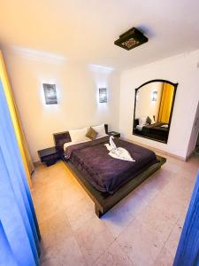 赫尔格达New Marina Hurghada Suite的一间卧室设有一张大床和一个大镜子