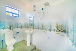 阿鲁特伽马Apartments by Tyzon的浴室设有卫生间和墙上树木淋浴。
