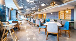 贵阳贵阳会展中心亚朵酒店的一间配备有桌子和蓝色椅子的用餐室
